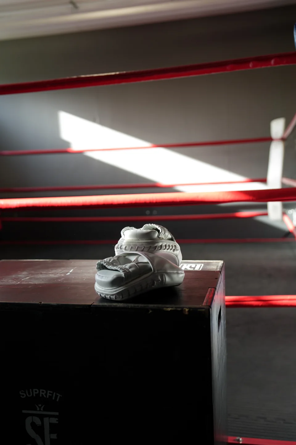 Boxschuh auf einer Trainingsbox vor roten Ringseilen